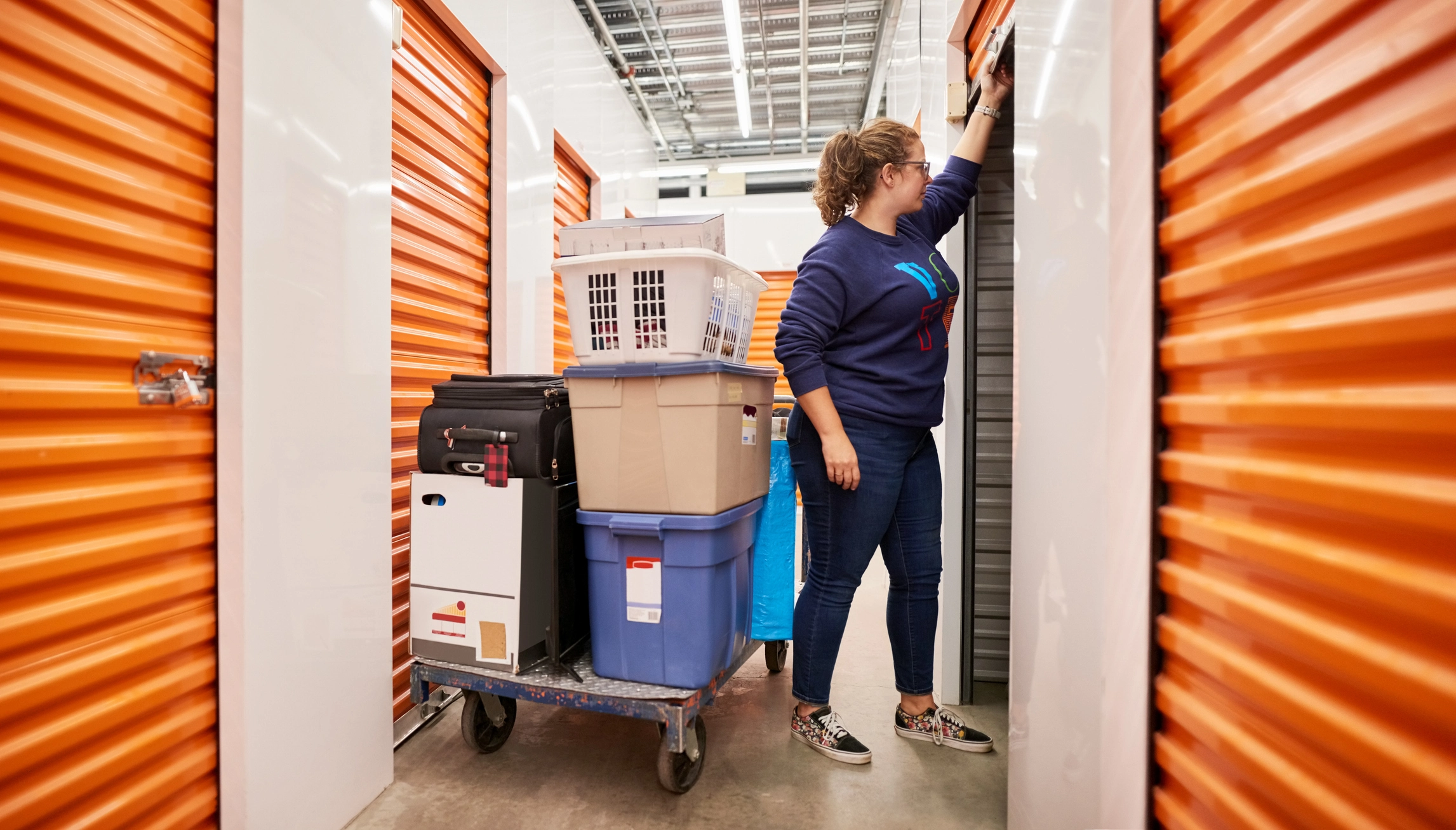 Une femme rangeant ses affaires dans sa box de stockage