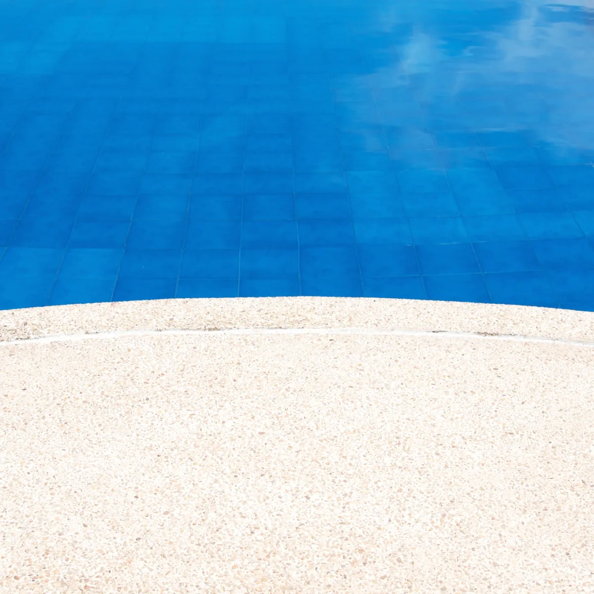 Abords d'une piscine sublimés par une moquette de pierre, alliant élégance et sécurité antidérapante.