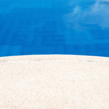 Abords d'une piscine sublimés par une moquette de pierre, alliant élégance et sécurité antidérapante.