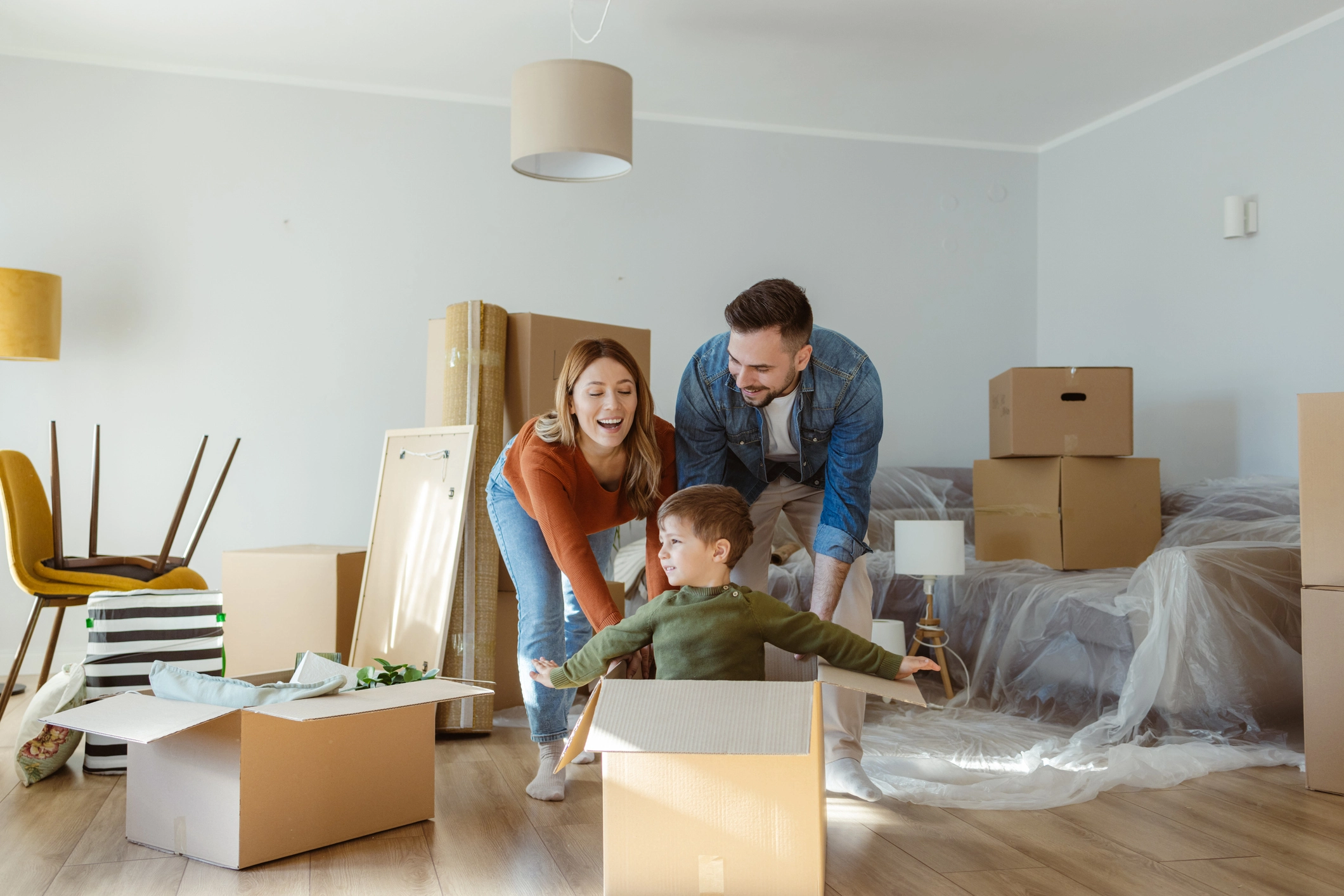 Une famille joyeuse et enjouée s'amuse à emménager dans un nouvel appartement