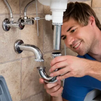 Homme réparant des équipements sanitaires