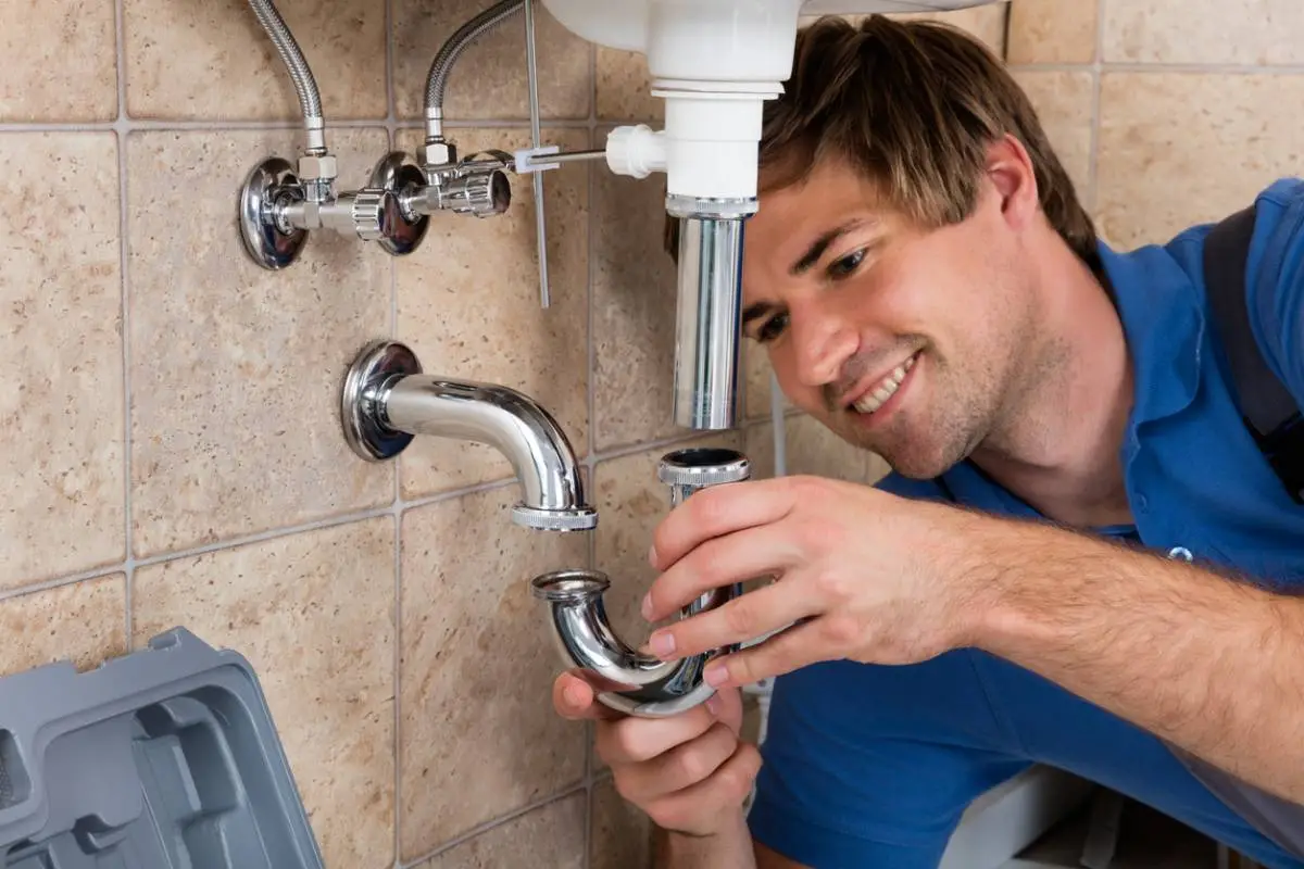 Homme réparant des équipements sanitaires